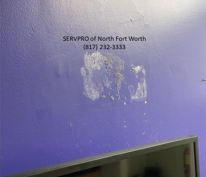 image containing indoor wall painted purple with dirt and debris attached