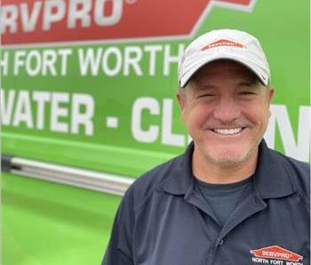 Male standing in front of green van with Servpro Logo
